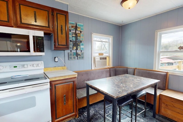 21701 259th St, Delhi, IA 52223 - kitchen featuring white appliances, light countertops, ornamental molding, cooling unit, and brown cabinetry