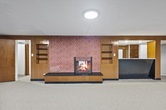 7224 Dartmoor Ave, Greendale, WI 53129 - unfurnished living room featuring wooden walls, a fireplace, and speckled floor