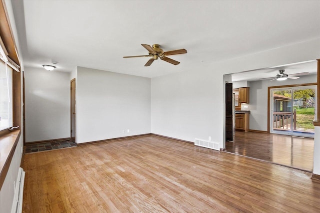 7224 Dartmoor Ave, Greendale, WI 53129 - unfurnished living room featuring ceiling fan, light wood-style flooring, baseboards, and a baseboard radiator