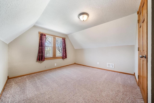 2780 Humboldt Rd, Green Bay, WI 54311 - additional living space featuring light carpet, lofted ceiling, baseboards, and a textured ceiling