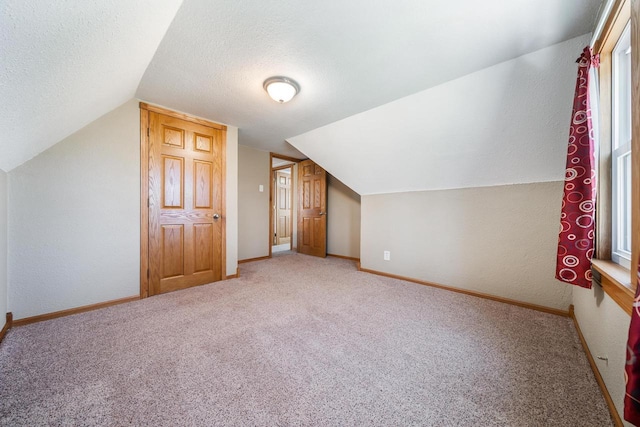 2780 Humboldt Rd, Green Bay, WI 54311 - additional living space with carpet, a textured ceiling, lofted ceiling, and baseboards