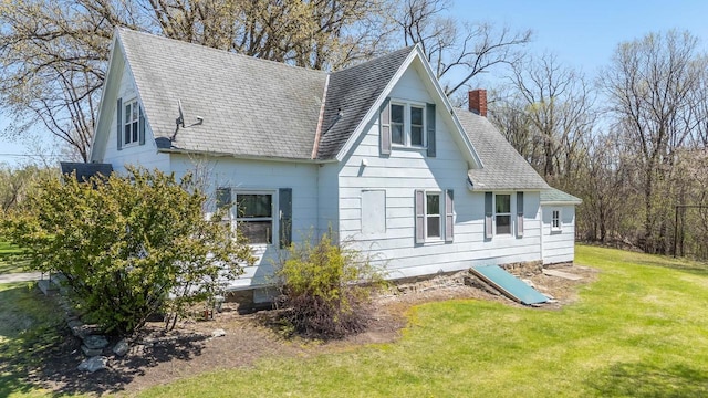 2780 Humboldt Rd, Green Bay, WI 54311 - view of side of home featuring a shingled roof, a yard, and a chimney