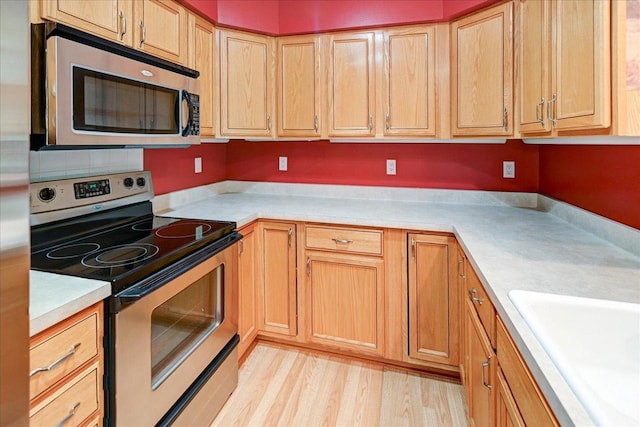 7910 N Brookline Dr, Madison, WI 53719 - kitchen with appliances with stainless steel finishes, light countertops, light wood finished floors, and a sink