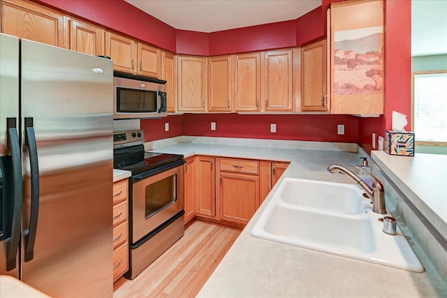 7910 N Brookline Dr, Madison, WI 53719 - kitchen featuring appliances with stainless steel finishes, a sink, light wood-type flooring, and light countertops