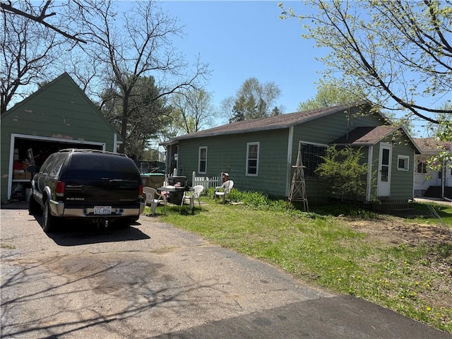 view of side of home with driveway, a garage, and a yard