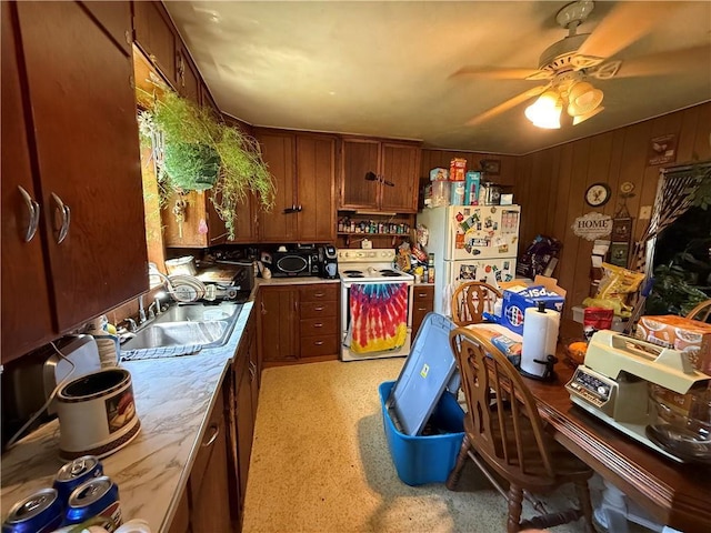 kitchen with white appliances, a sink, light countertops, and a ceiling fan
