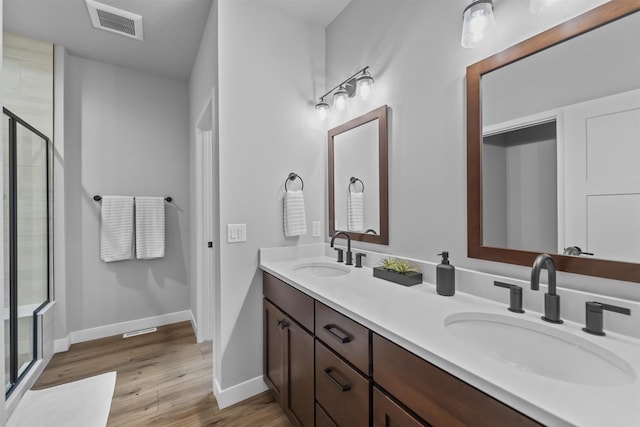 2149 Rosenberg Ln, Sun Prairie, WI 53590 - full bathroom with a shower stall, wood finished floors, baseboards, and double vanity