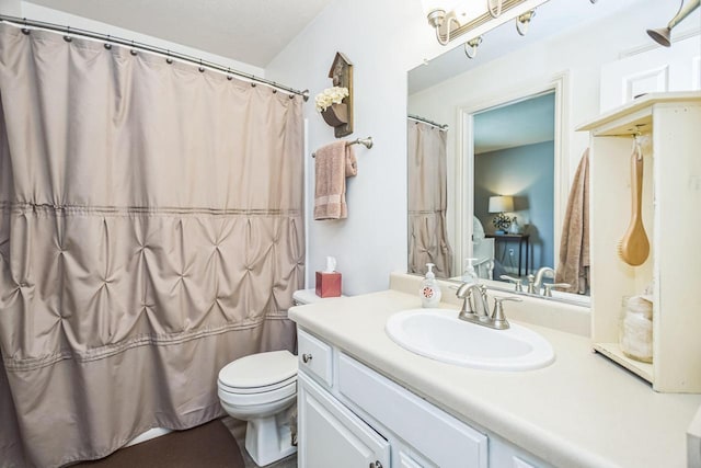 bathroom with toilet, vanity, and a shower with curtain