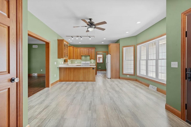 2210 Alban Ln, Prairie Du Sac, WI 53578 - kitchen featuring white appliances, open floor plan, baseboards, a ceiling fan, and a peninsula