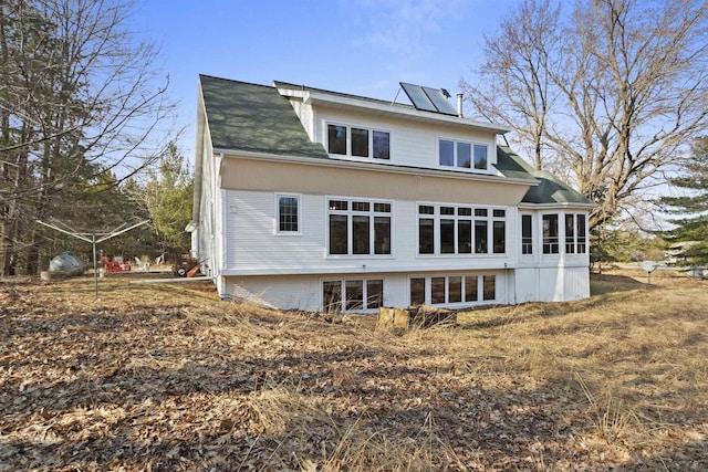 1229 Riverwood Ln, Sobieski, WI 02413 - rear view of house with roof mounted solar panels, roof with shingles, and a sunroom