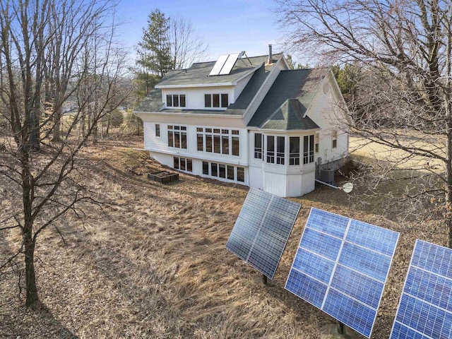 1229 Riverwood Ln, Sobieski, WI 02413 - rear view of property featuring ground mounted solar panels, central air condition unit, a chimney, and roof with shingles