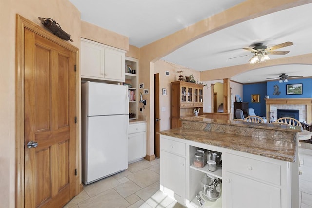 1229 Riverwood Ln, Sobieski, WI 02413 - kitchen featuring freestanding refrigerator, a ceiling fan, open shelves, arched walkways, and stone countertops