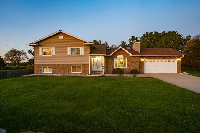 N2664 Grand Path, Wautoma, WI 54982 - split level home with driveway, an attached garage, a front lawn, and a chimney