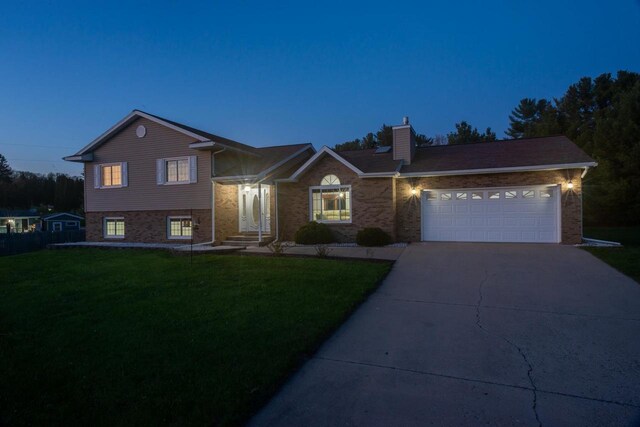 N2664 Grand Path, Wautoma, WI 54982 - split level home featuring driveway, a front lawn, a garage, and brick siding