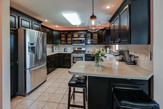 717 Larvik Ln, Stoughton, WI 53589 - kitchen featuring appliances with stainless steel finishes, a peninsula, tasteful backsplash, light countertops, and recessed lighting