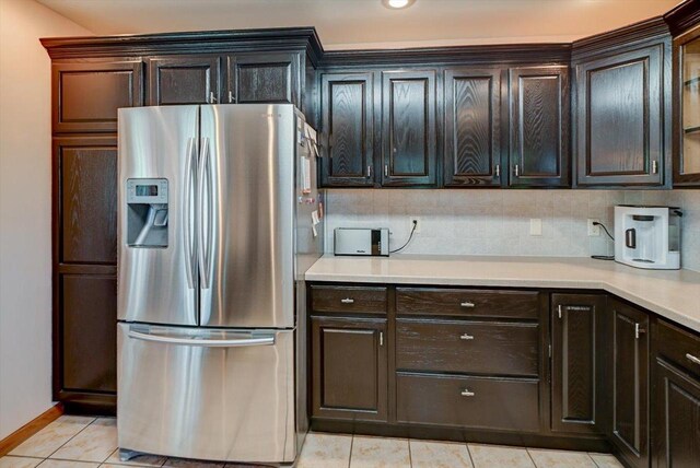 717 Larvik Ln, Stoughton, WI 53589 - kitchen with stainless steel fridge, light countertops, light tile patterned floors, baseboards, and backsplash