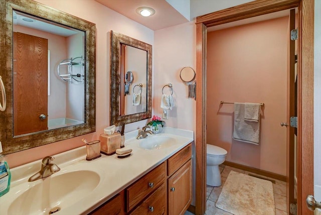 717 Larvik Ln, Stoughton, WI 53589 - bathroom featuring toilet, double vanity, tile patterned flooring, and baseboards