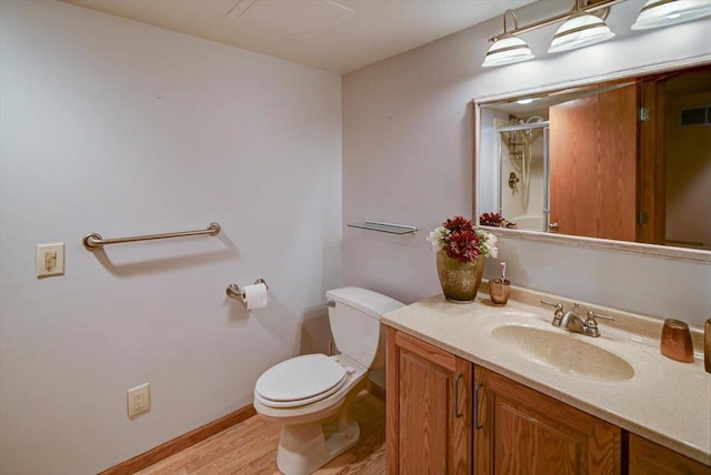 717 Larvik Ln, Stoughton, WI 53589 - bathroom with toilet, wood finished floors, vanity, a shower, and baseboards