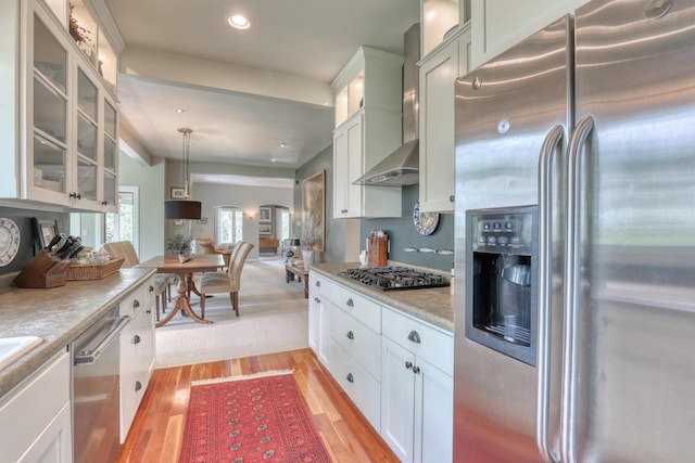 N40W27836 Glacier Rd, Pewaukee, WI 53072 - kitchen featuring appliances with stainless steel finishes, wall chimney exhaust hood, light countertops, glass insert cabinets, and white cabinetry
