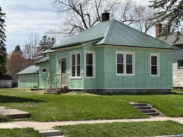 613 Vaughn Ave, Ashland, WI 54806 - view of front of home with a chimney, entry steps, a front lawn, and metal roof