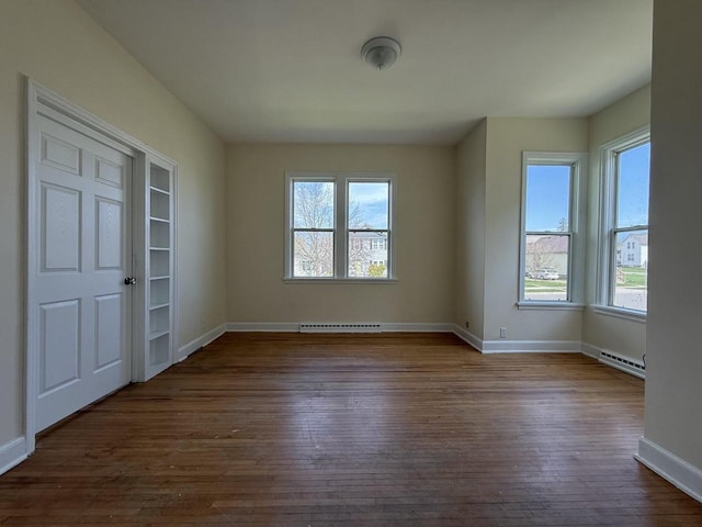 613 Vaughn Ave, Ashland, WI 54806 - spare room featuring healthy amount of natural light, dark wood-style flooring, baseboards, and a baseboard heating unit