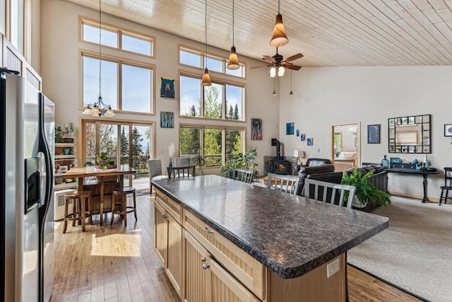 87985 Bark Point Rd, Herbster, WI 54844 - kitchen featuring open floor plan, a wood stove, stainless steel fridge, dark countertops, and healthy amount of natural light