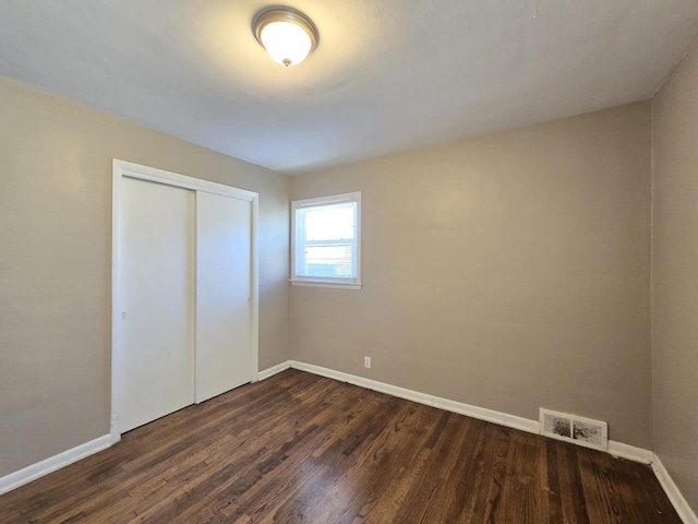 6321 W Keefe Avenue Parkway Unit 6323, Milwaukee, WI 53216 - unfurnished bedroom with dark wood-style floors, a closet, and baseboards
