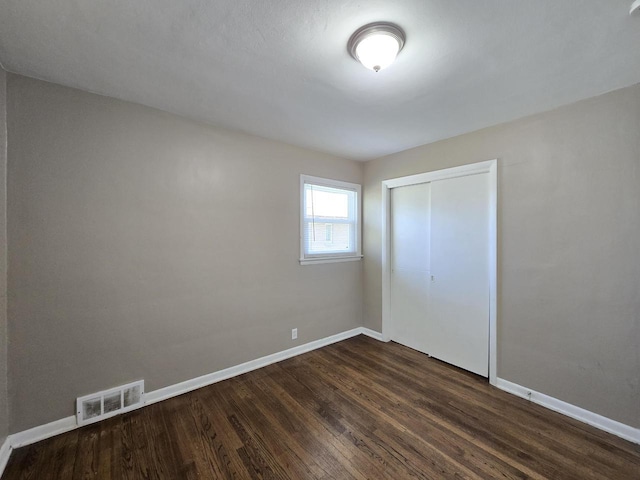 6321 W Keefe Avenue Parkway Unit 6323, Milwaukee, WI 53216 - unfurnished bedroom featuring baseboards, dark wood-style flooring, and a closet