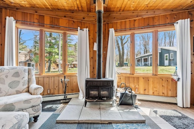 111 Rolphs Point Dr, Shell Lake, WI 54871 - sitting room featuring a wood stove, baseboard heating, wooden walls, wooden ceiling, and tile patterned flooring