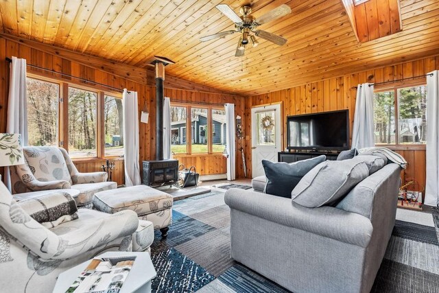 111 Rolphs Point Dr, Shell Lake, WI 54871 - living room with a wood stove, wooden walls, ceiling fan, and wood ceiling