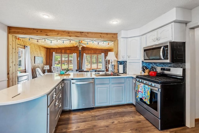 111 Rolphs Point Dr, Shell Lake, WI 54871 - kitchen featuring appliances with stainless steel finishes, a peninsula, a sink, wood finished floors, and light countertops