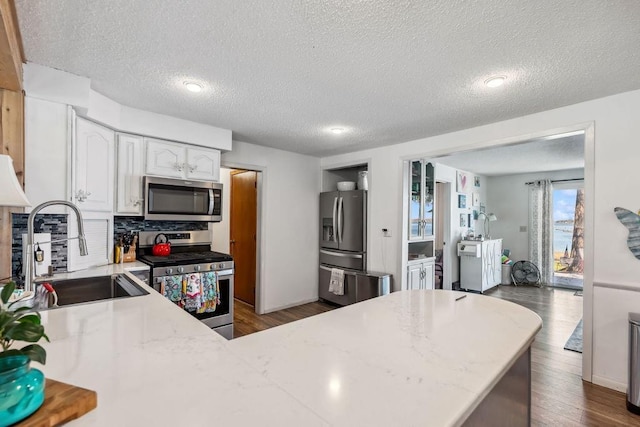 111 Rolphs Point Dr, Shell Lake, WI 54871 - kitchen featuring stainless steel appliances, a sink, a textured ceiling, white cabinetry, and dark wood finished floors