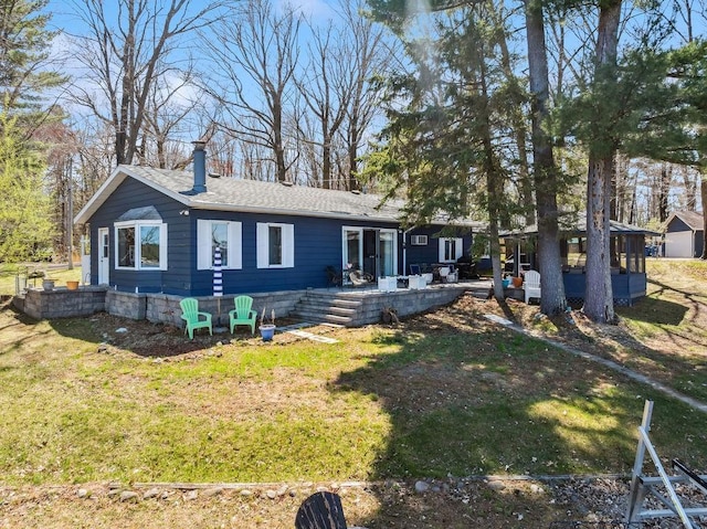 111 Rolphs Point Dr, Shell Lake, WI 54871 - rear view of house featuring a chimney, a lawn, and a shingled roof