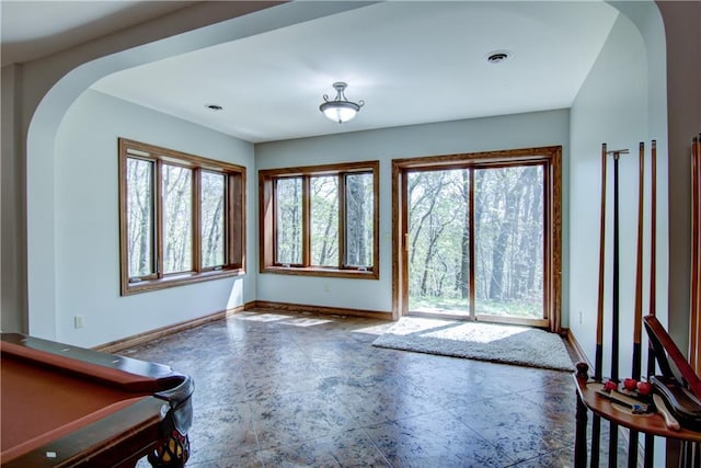4221 Lassek Ct, Eau Claire, WI 54703 - unfurnished living room featuring arched walkways, baseboards, and healthy amount of natural light