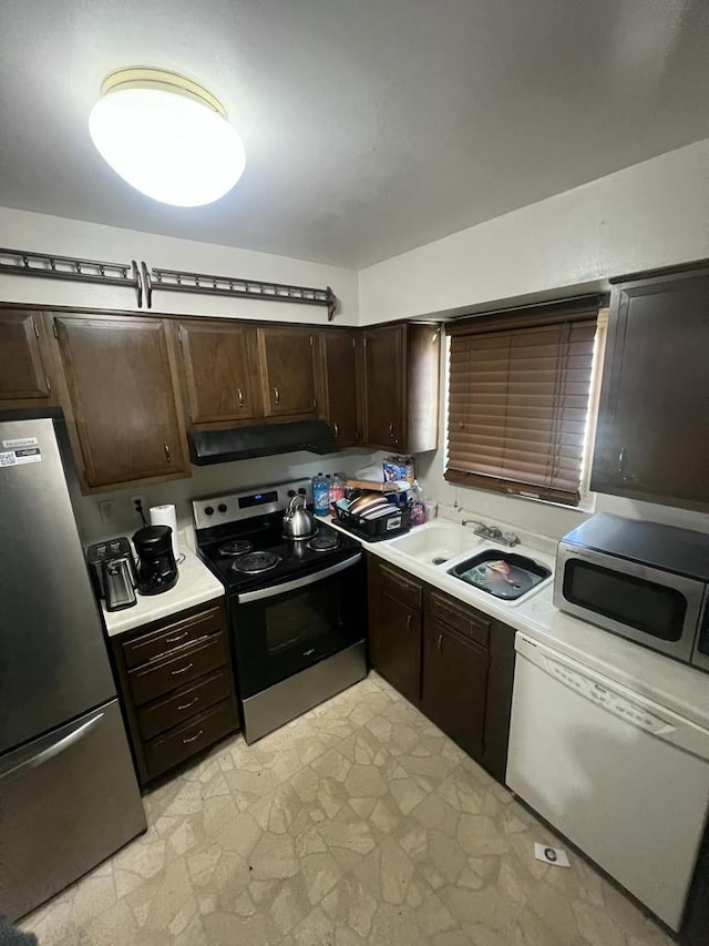 8657 N 73rd St, Milwaukee, WI 53223 - kitchen with appliances with stainless steel finishes, under cabinet range hood, a sink, light countertops, and dark brown cabinets