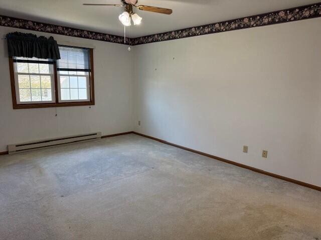 spare room with a baseboard heating unit, a ceiling fan, light colored carpet, and baseboards