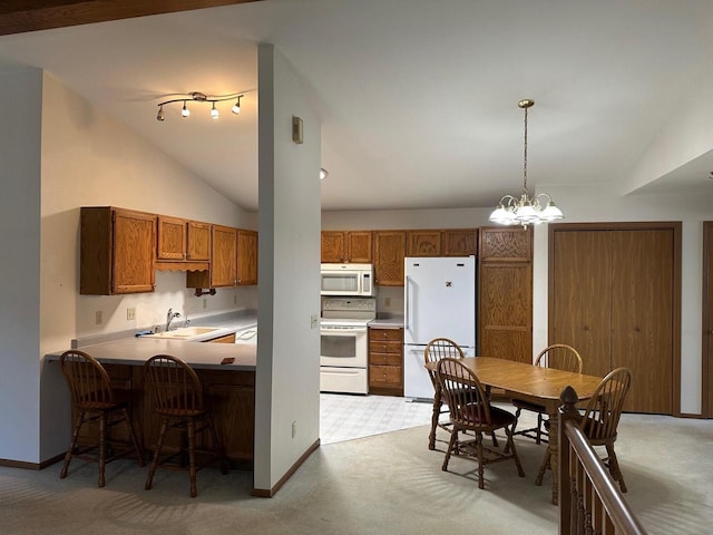 kitchen featuring white appliances, light colored carpet, brown cabinetry, lofted ceiling, and a peninsula