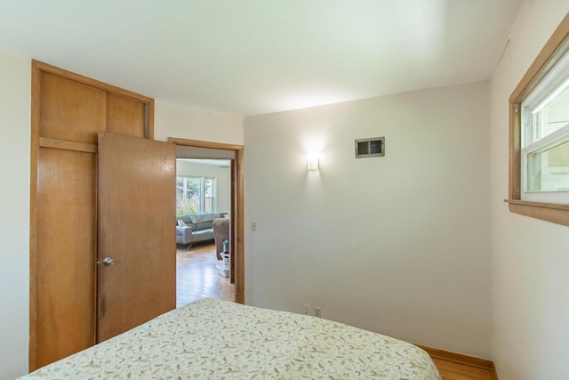 552 11th St, Kenosha, WI 53140 - bedroom featuring wood finished floors, multiple windows, and a closet