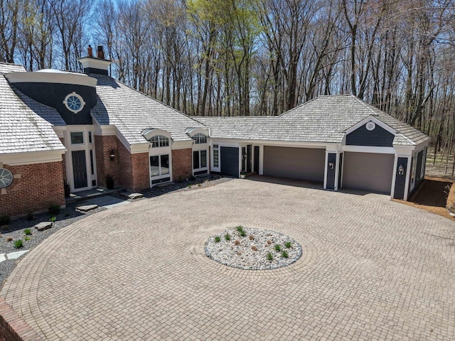 889 Horns Corners Rd, Cedarburg, WI 53012 - view of front of home featuring a garage, curved driveway, a chimney, and brick siding