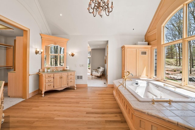 889 Horns Corners Rd, Cedarburg, WI 53012 - full bathroom with lofted ceiling, wood finished floors, a tub with jets, vanity, and a chandelier