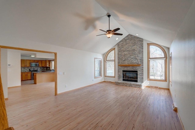 821 Ondossagon Way, Madison, WI 53719 - unfurnished living room featuring a ceiling fan, light wood-style floors, high vaulted ceiling, a fireplace, and baseboards