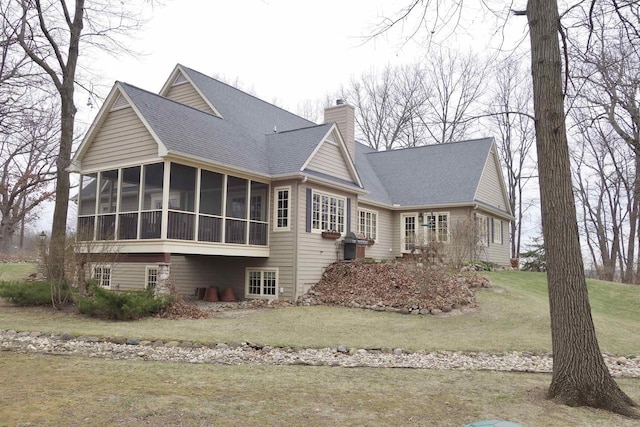N3684 Petrie Rd, Lake Geneva, WI 53147 - view of home's exterior featuring a sunroom, a chimney, roof with shingles, and a lawn