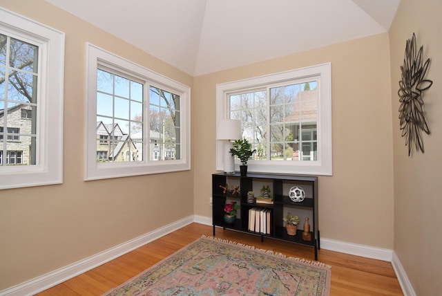 doorway to outside with plenty of natural light, baseboards, wood finished floors, and lofted ceiling