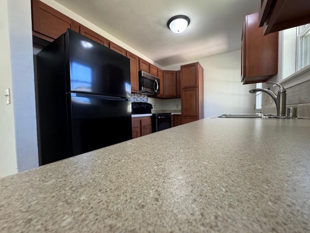 4814 Freese Ln, Madison, WI 53718 - kitchen featuring black appliances, a sink, light countertops, brown cabinets, and tasteful backsplash