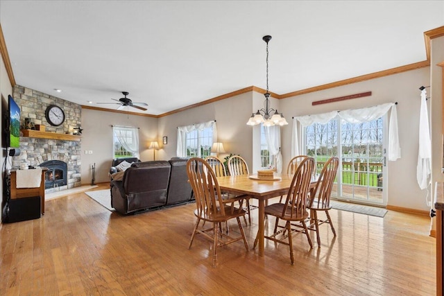 2583 Countryside Ln, Richfield, WI 53076 - dining space featuring light wood-type flooring, a ceiling fan, ornamental molding, a stone fireplace, and a chandelier