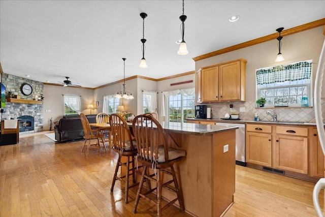 2583 Countryside Ln, Richfield, WI 53076 - kitchen with dishwasher, a ceiling fan, light wood finished floors, decorative backsplash, and a center island