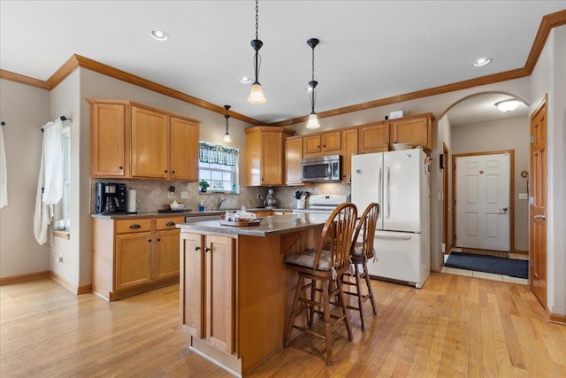 2583 Countryside Ln, Richfield, WI 53076 - kitchen with stainless steel microwave, freestanding refrigerator, arched walkways, range, and a center island