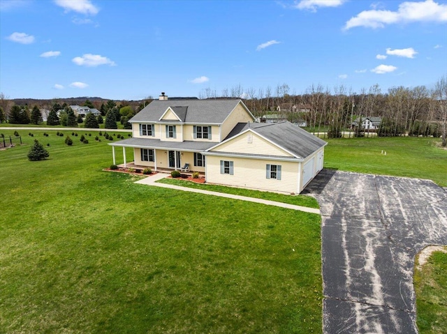 2583 Countryside Ln, Richfield, WI 53076 - view of front of property with asphalt driveway, covered porch, a chimney, and a front lawn