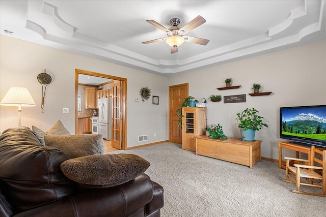 2583 Countryside Ln, Richfield, WI 53076 - living room featuring a raised ceiling, light carpet, ceiling fan, and baseboards