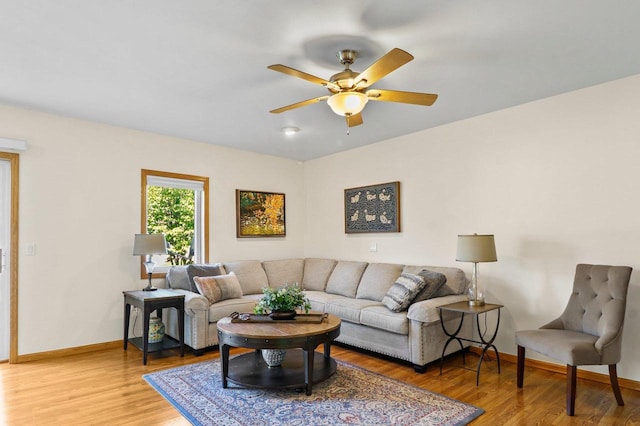 living room featuring light wood-type flooring, ceiling fan, and baseboards